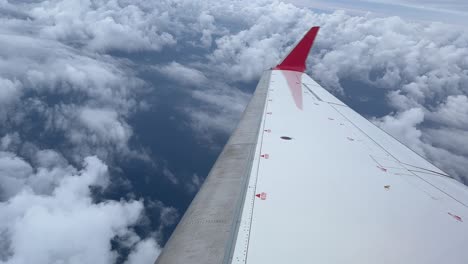 Weißer-Rechter-Düsenflügel-Mit-Rotem-Winglet-Blick,-Der-Das-Meer-In-Einer-Rechtskurve-überfliegt