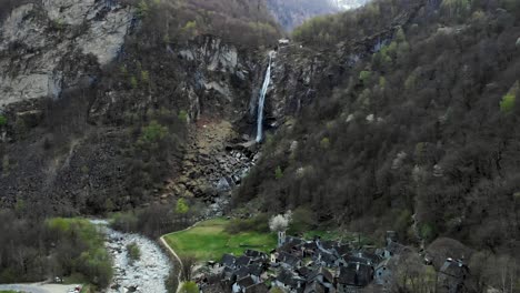 Luftüberführung-über-Die-Dächer-Der-Alten-Steinhäuser-Des-Dorfes-Foroglio-Im-Tessin,-Schweiz-In-Richtung-Des-Wasserfalls-In-Der-Abenddämmerung