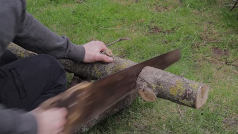 Struggling-to-cut-jungle-wood-with-blunt-handsaw