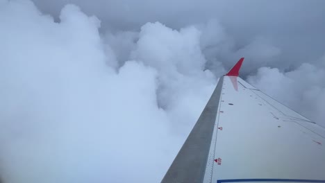 Rechter-Flügel-Eines-Jets,-Der-Durch-Cumuluswolken-Fliegt