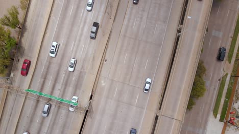 Aerial-view-above-traffic-on-the-Woodall-Rodgers-freeway,-in-sunny-Dallas,-USA---top-down,-drone-shot