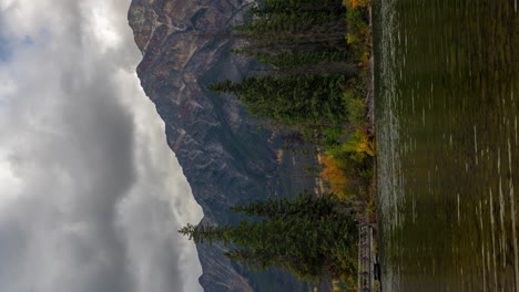 Lapso-De-Tiempo-Vertical-De-4k,-Isla-Piramidal-Y-Puente-Sobre-El-Lago-Piramidal,-Nubes-Oscuras-Dramáticas-Moviéndose-Sobre-Los-Picos-Del-Parque-Nacional-Jasper,-Canadá