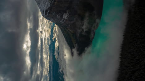 Vertikaler-4K-Zeitraffer-Einer-Großartigen-Atmosphärenszene-über-Einem-Gletschersee-Und-Schneebedeckten-Bergen,-Wolken-Und-Nebelumkehrungen,-Lake-Louise,-Banff-Nationalpark,-Alberta,-Kanada