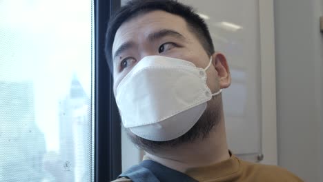 POV-to-a-man-wearing-mask-while-ridding-subway-public-transportation-in-Bangkok