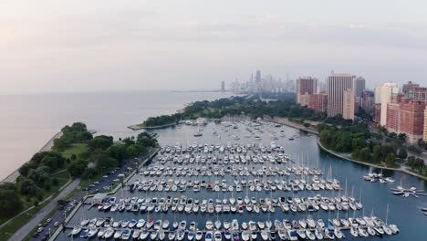 High-Aerial-View-of-Belmont-Harbor,-Chicago-Skyline-in-Distance-in-the-Morning