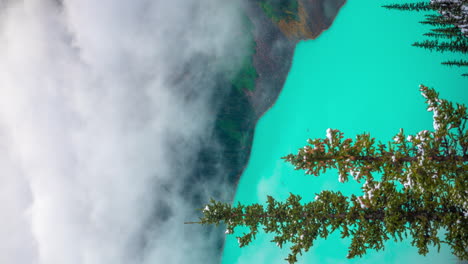 Lapso-De-Tiempo-Vertical-De-4k,-Nubes-Moviéndose-Y-Desapareciendo-Sobre-El-Agua-Azul-Del-Lago-Louise,-Parque-Nacional-De-Banff,-Alberta,-Canadá
