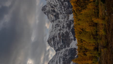 Vertikaler-4k-Zeitraffer,-Dramatische-Dunkle-Wolken,-Die-Sich-An-Kalten-Herbsttagen-Im-Banff-Nationalpark,-Kanada,-über-Schneebedeckte-Gipfel-Und-Lärchental-Bewegen