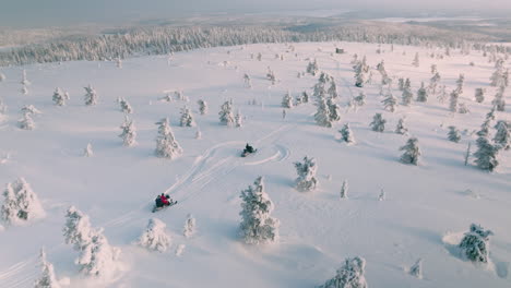 Turistas-Montando-Motos-De-Nieve-A-Través-De-La-Espesa-Nieve-En-Finlandia-Durante-El-Invierno---Toma-Aérea