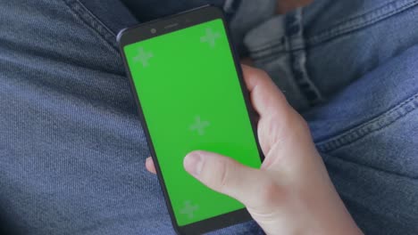 Man's-thumb-swiping-right-on-green-screen-mobile-device
