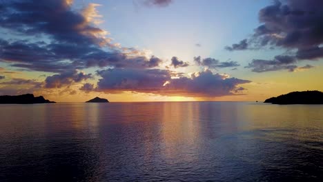 Dramatische-Wolken-Bei-Orangefarbenem-Sonnenuntergang-Mit-Ruhigem-Meer-Und-Inseln,-Luftaufnahme
