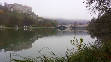 Burghausen-castle,-the-worlds-longest-castle-reflecting-in-a-lake-on-a-foggy-day