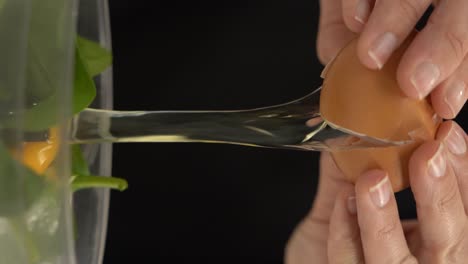 Vertical-video-of-cracking-an-egg-over-a-bowl