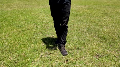 A-man-with-black-trouser-and-black-shoe-walking-in-the-field