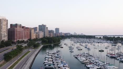 Establishing-Shot-Above-Boat-Harbor-in-Urban-City,-Pan-Right-Reveals-Amazing-Sunrise