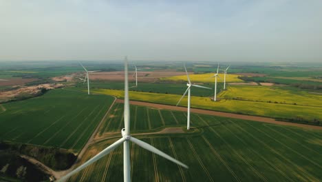 Rising-aerial-with-tilt-down-over-wind-turbines-in-the-countryside-of-Yorkshire-and-fields-of-rapeseed
