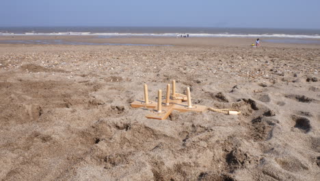 Lustige-Reifenspiele-Mit-Einer-Familie,-Die-Am-Strand-Im-Sand-Am-Meer-Spielt