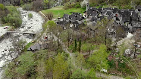 Überflug-Aus-Der-Luft-über-Das-Dorf-Foroglio-Im-Tessin,-Schweiz,-Mit-Einer-Kameraschwenkbewegung-Von-Den-Dächern-Bis-Zum-Großen-Wasserfall