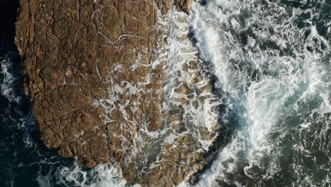 Waves-Splashing-On-The-Sea-Rocks-In-Pula,-Istria,-Croatia---aerial-top-down