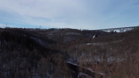 Drohne-Fliegt-Im-Winter-Zwischen-Bäumen,-Um-Die-Ländliche-Landschaft-Und-Die-Höchste-Eisenbahnbrücke-Deutschlands-Zu-Enthüllen