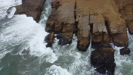 Drone-footage-of-a-rocky-outcrop-on-a-beach-in-Lima-Peru