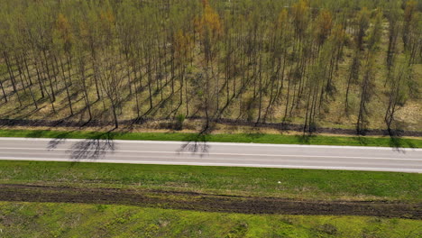 Aerial-shot-of-two-black-cars-on-the-road-through-wooded-landscape