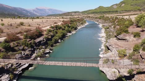 Wooden-Suspension-Bridge-across-Vjosa-River,-Albania---Aerial-Fly-Over