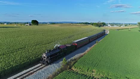 An-Aerial-View-of-an-Antique-Steam-Passenger-Train-Blowing-Smoke-and-Steam-Traveling-Thru-Fertile-Corn-Fields-on-a-Beautiful-Sunny-Summer-Day