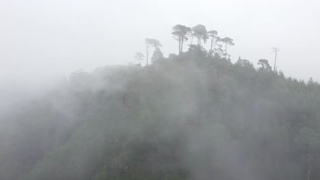 Luftdrohnenansicht-Der-Kleinen-Kapelle-Auf-Dem-Gipfel-Des-Berges,-Umgeben-Von-Nebel-Und-Wolken