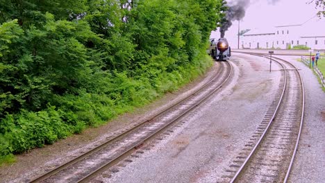 An-Elevated-View-of-a-Large-Steam-Engine-Passenger-Train-Blowing-Black-Smoke-Passing-on-a-Siding-on-a-Cloudy-Day