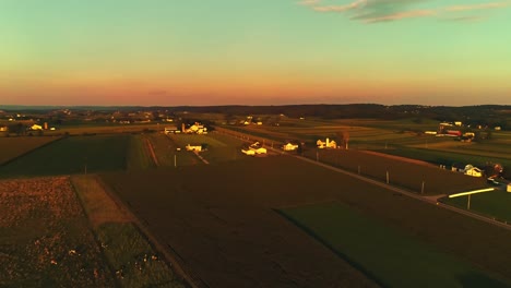 Eine-Luftaufnahme-Von-Maisfeldern-Und-Fruchtbarem-Ackerland-Und-Bauernhöfen-Zur-Goldenen-Stunde-An-Einem-Sonnigen-Sommertag