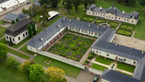 Manicured-gardens-and-old-school-charm,-The-Castle-Bon-Repos-near-Prague,-aerial-tilt-down