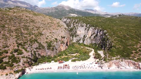 Gjipe-Beach-and-Canyon,-Albania---Reversing-Aerial-of-White-Sandy-Beach-and-Blue-Sea