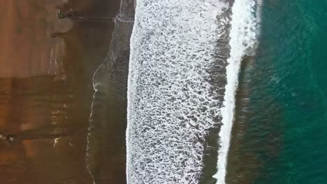 Drohnenansicht-Des-Wunderschönen-Braunen-Sandstrandes-Mit-Weißen-Wellen,-Die-Sich-Am-Ufer-Waschen,-Und-Türkisblauem-Wasser