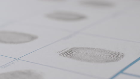Close-Up-Of-Fingerprint-Being-Applied-To-White-Paper