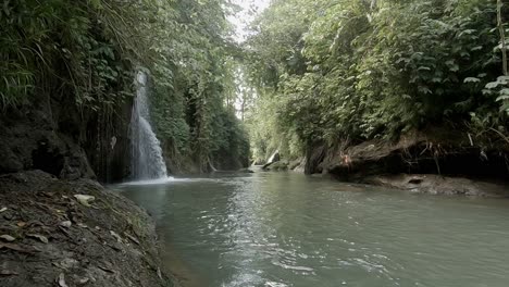 Cascada-En-Un-Río-Que-Fluye-Lentamente-Y-Un-Exuberante-Valle-De-Selva-Verde