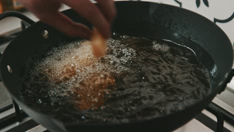 Placing-potato-chips-one-by-one-into-pan-with-hot-oil