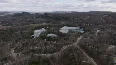 Frozen-Lake-And-Vast-Forest-Landscape-In-Quebec,-Canada---aerial-shot