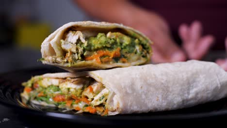 Slowmotion-Präsentation-Von-Köstlichem-Bio-Huhn-Und-Gemüse-Burrito-Auf-Elegantem-Schwarzem-Teller-Von-Lateinamerikanischer-Köchin-4k-Mexikanisches-Essensmaterial