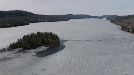 Eisbedecktes-Wasser-Des-Sees-Tremblant-Mit-Insel-In-Den-Laurentides,-Quebec,-Kanada