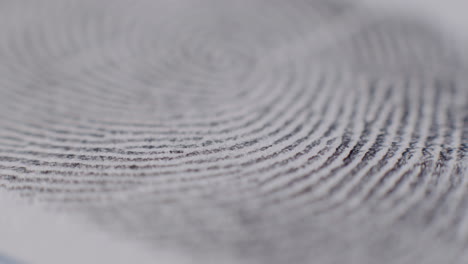 Extreme-Close-Up-Of-Fingerprint-Being-Applied-To-Paper-With-Focus-Across-Lower-Third-Of-Frame