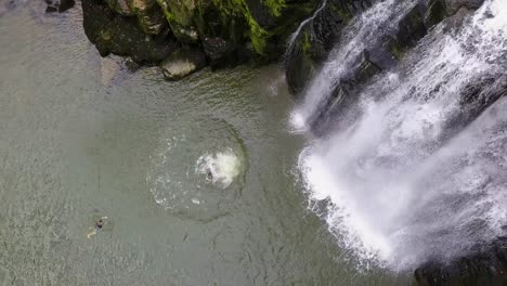 Junger-Akrobat-Springt-Von-Einer-Klippe-In-Der-Nähe-Eines-Wasserfalls-Im-Fluss-Doubs,-Schweiz