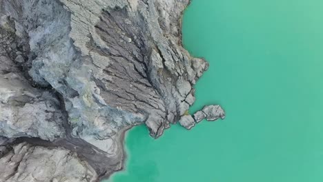 Dramatic-aerial-view-of-a-creator-at-Kawah-Ijen-volcano-with-turquoise-sulfur-lake