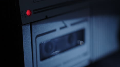 Rack-Fokus-Vom-Roten-Mikrokassetten-Aufnahmelicht-Bis-Zu-Den-Sich-Im-Hintergrund-Drehenden-Spulen