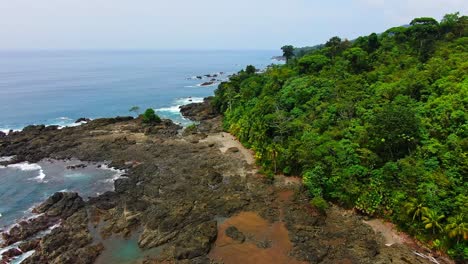 HD-Aerial-Drone-Footage-Of-Rocky-Paradise-Jungle-Coast-With-Waves-Breaking-On-Rocky-Bay