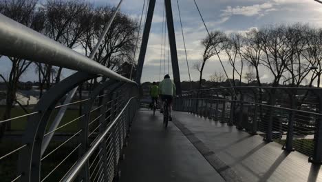Cyclists-ride-on-a-pedestrian-bridge-in-Auckland-New-Zealand