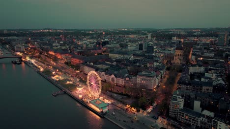 Drone-Aerial-Shot-of-Mainz-at-a-summer-wine-festival-at-the-Rhine-river-bank-during-sunset-showing-the-dome-and-the-Christus-church