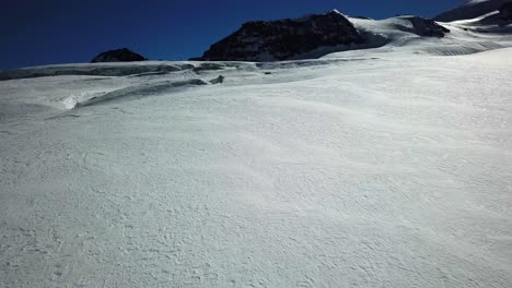 Blick-Auf-Eine-Verschneite-Ebene-Von-Einer-Mavic-Drohne-In-Den-Schweizer-Alpen
