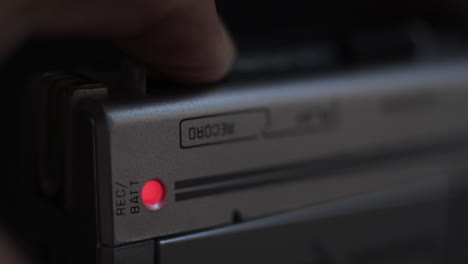 Close-Up-Of-Finger-Pressing-Record-Button-Of-Microcassette-Recorder-And-Light-Coming-On