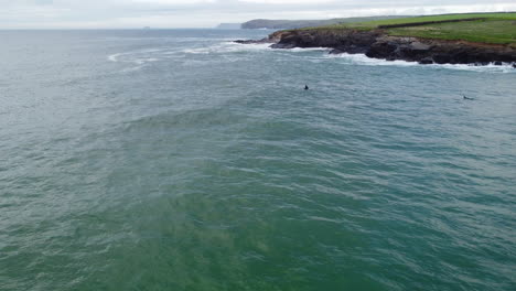 Surfers-enjoying-the-rough-seas-of-the-Cornwall-coast-at-Harlyn-Bay