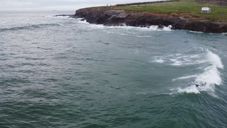 Surfer-enjoying-the-rough-seas-of-the-Cornwall-coast-at-Harlyn-Bay